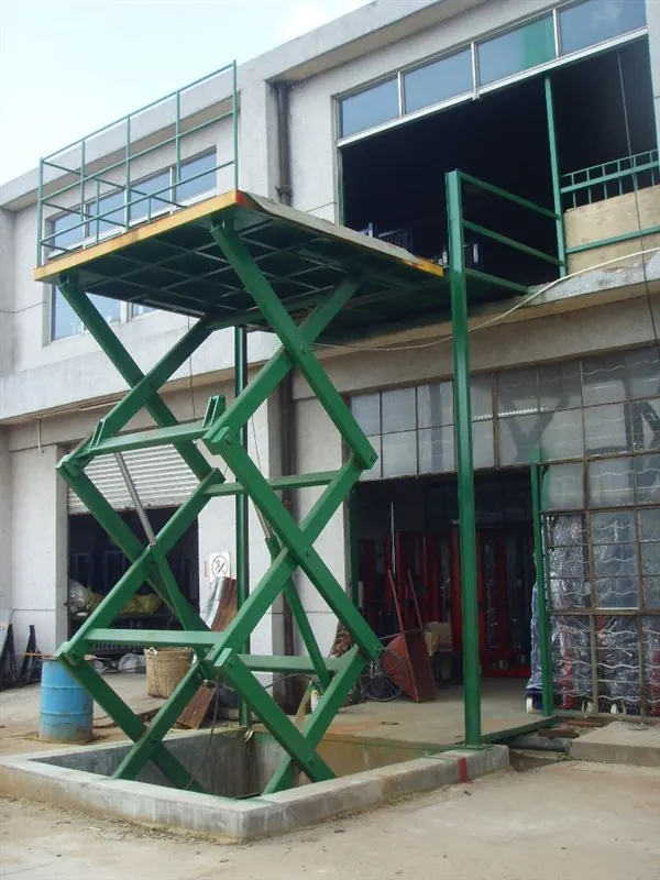Fixed multistage hydraulic scissor lift raised to an upper-floor opening